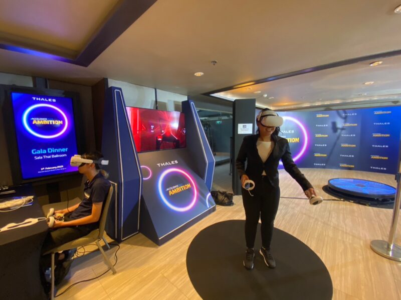 ผู้เข้าร่วมงานทดลองเล่น VR ที่บูธ Thales