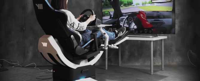 ผู้ใช้กำลังนั่งบนเก้าอี้ VR Yaw2 และเล่นเกมแข่งรถบนหน้าจอ, พวงมาลัยและอุปกรณ์เสริมถูกใช้เพื่อจำลองการขับรถในเกม VR